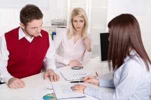Young couple has consultation with consultant at desk at office - פגיעה עצבית.